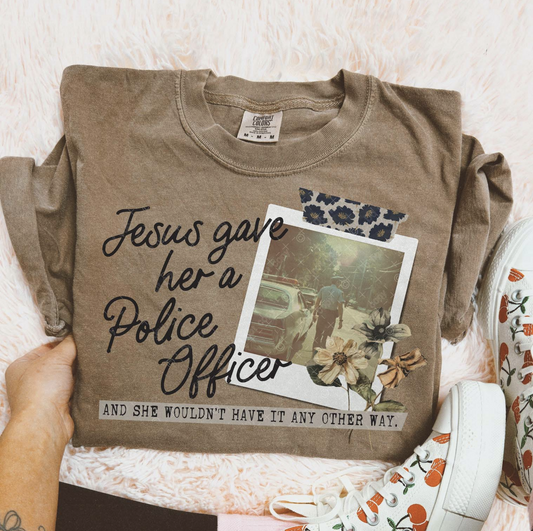 Brown Comfort Colors tee with Christian message “Jesus gave her a police officer” with floral photo design.
Close-up of faith-based police wife graphic on t-shirt.