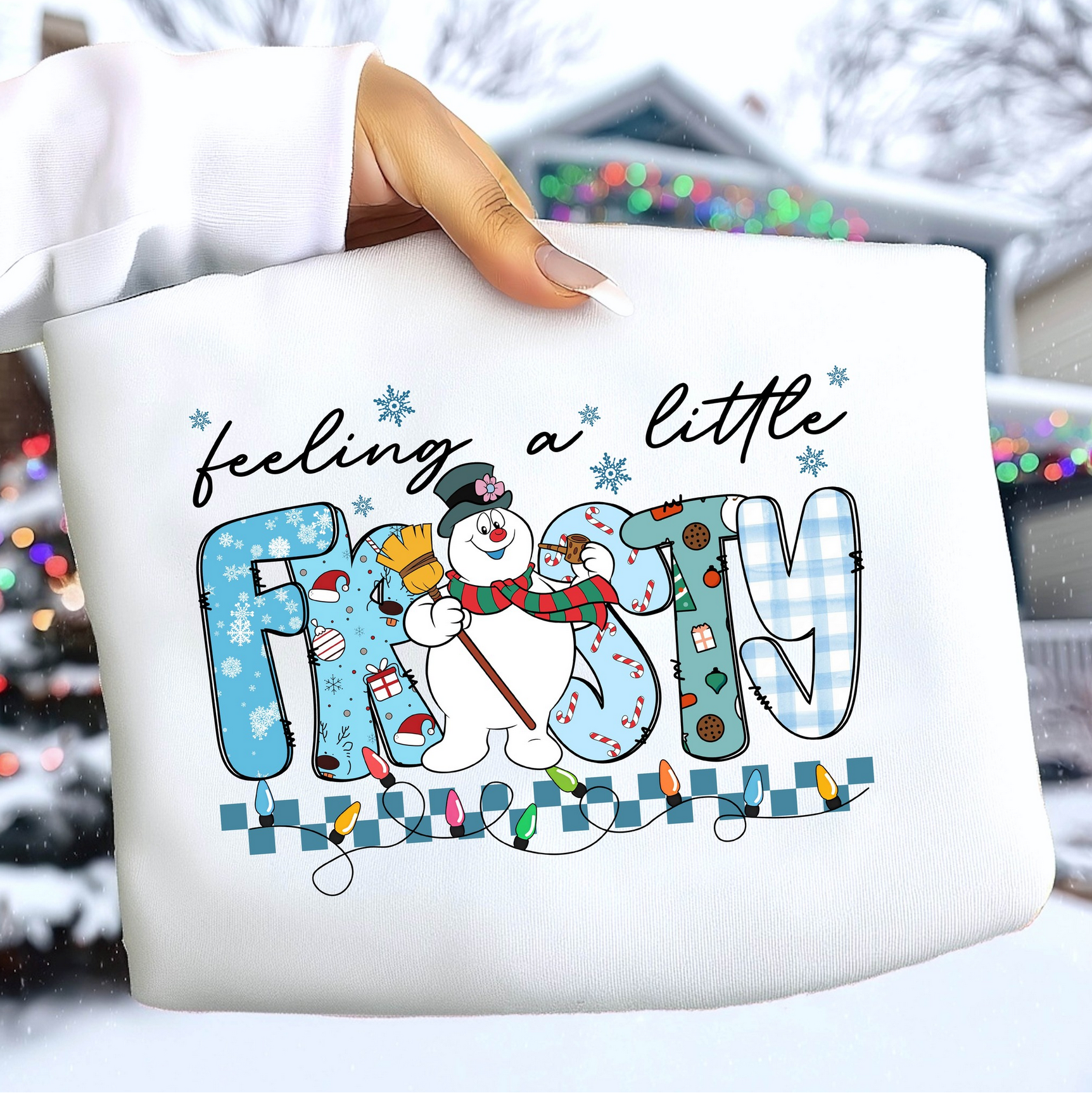 White sweatshirt with “Feeling a Little Frosty” snowman winter design.

Cute snowman holiday sweatshirt with patterned letters and lights.

Winter-themed crewneck featuring snowman and festive elements.

Cozy Christmas sweatshirt styled outdoors in winter setting.