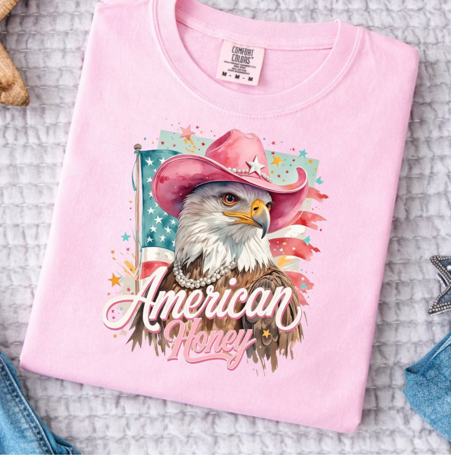 Pink Comfort Colors t-shirt featuring eagle with pink cowboy hat and “American Honey” patriotic graphic
