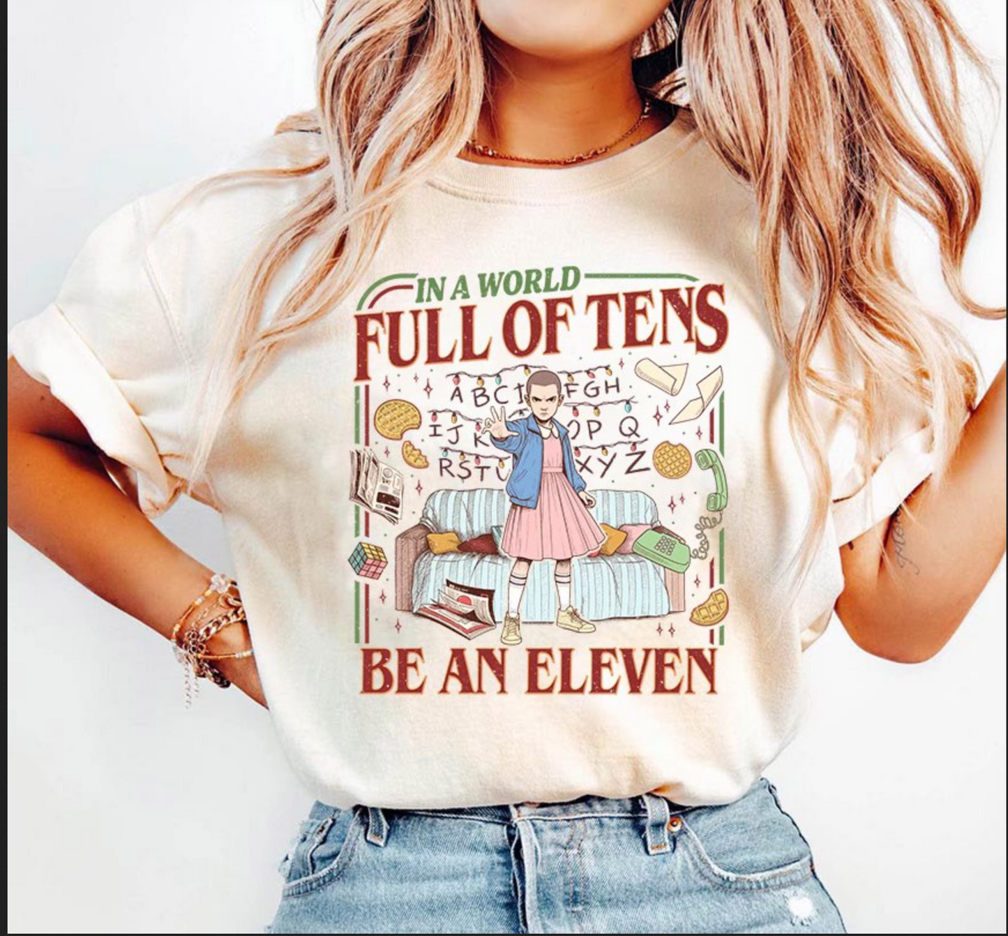 Cream graphic t-shirt featuring retro illustration and the phrase In a World Full of Tens Be an Eleven