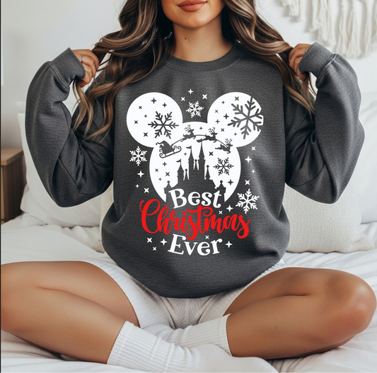 Dark gray sweatshirt with winter silhouette, snowflakes, and Best Christmas Ever text.

Festive holiday crewneck featuring snowflakes and castle-style silhouette.

Cozy Christmas sweatshirt with winter graphic and holiday bow.

Woman wearing dark gray holiday silhouette sweatshirt sitting indoors.