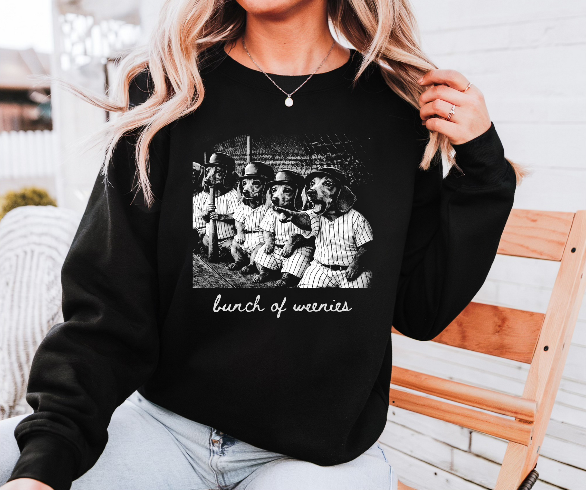 Black crewneck sweatshirt featuring dachshunds in baseball uniforms with the phrase bunch of weenies funny dog graphic design