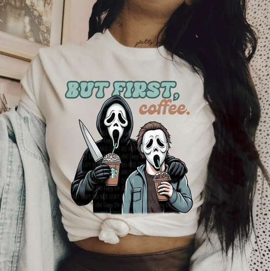 White graphic t-shirt with two Ghostface characters holding iced coffees, one with a knife, and text “But First, Coffee.”