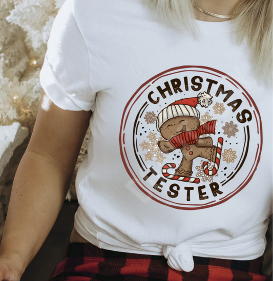 White Christmas Tester shirt with gingerbread cookie and candy cane graphic.

Cute gingerbread Christmas tee with snowflakes and festive artwork.

Holiday baking themed t-shirt styled for Christmas season.

Cozy gingerbread cookie graphic tee for winter outfits.