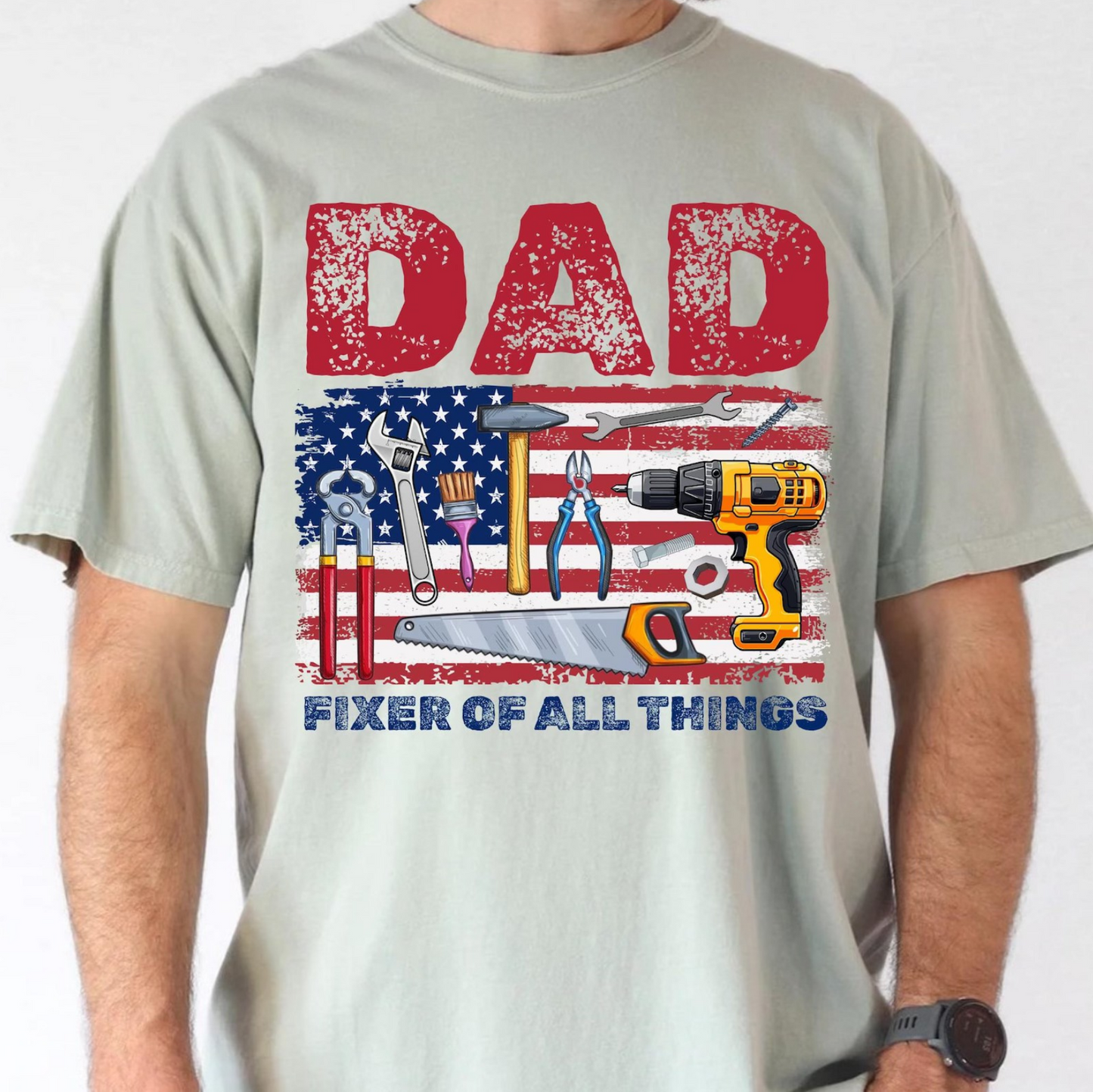 Gray t-shirt with American flag and tools design reading “Dad Fixer of All Things”