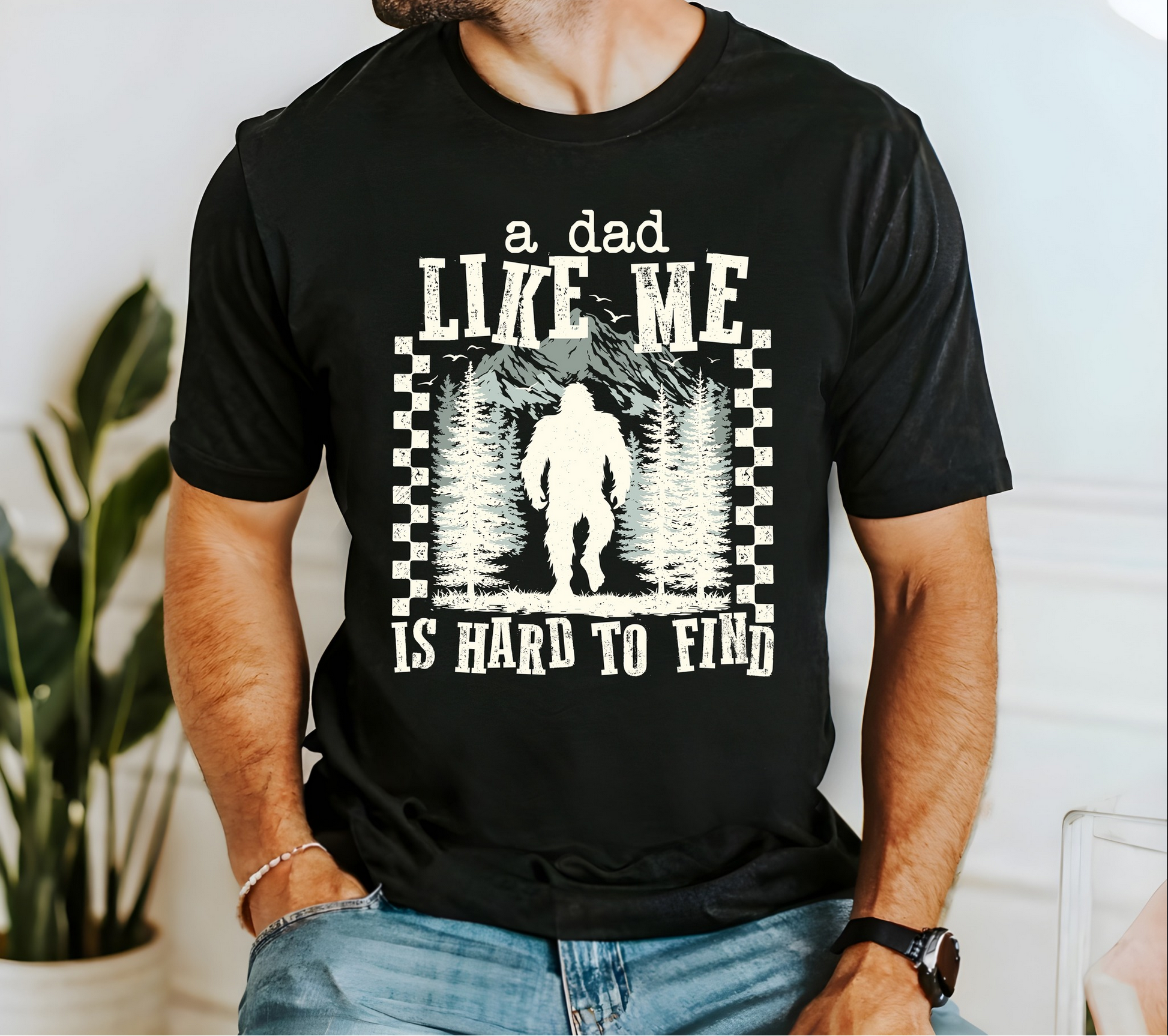 Black t-shirt featuring Bigfoot forest graphic with text “A Dad Like Me Is Hard To Find” for funny Father’s Day gift