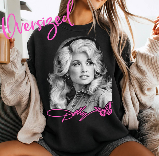 Model wearing a black crewneck sweatshirt featuring a large black-and-white Dolly Parton portrait with a bright pink signature and butterfly.

Search-engine page title: