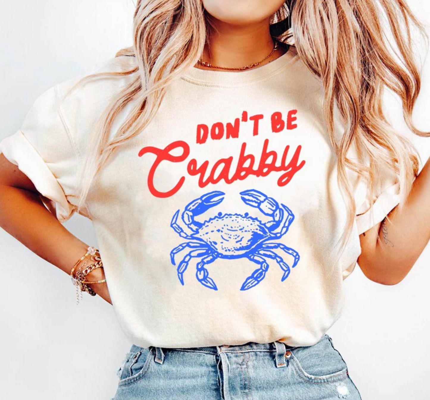 Cream graphic t-shirt featuring Don’t Be Crabby saying with blue crab design for cute coastal summer boutique fashion