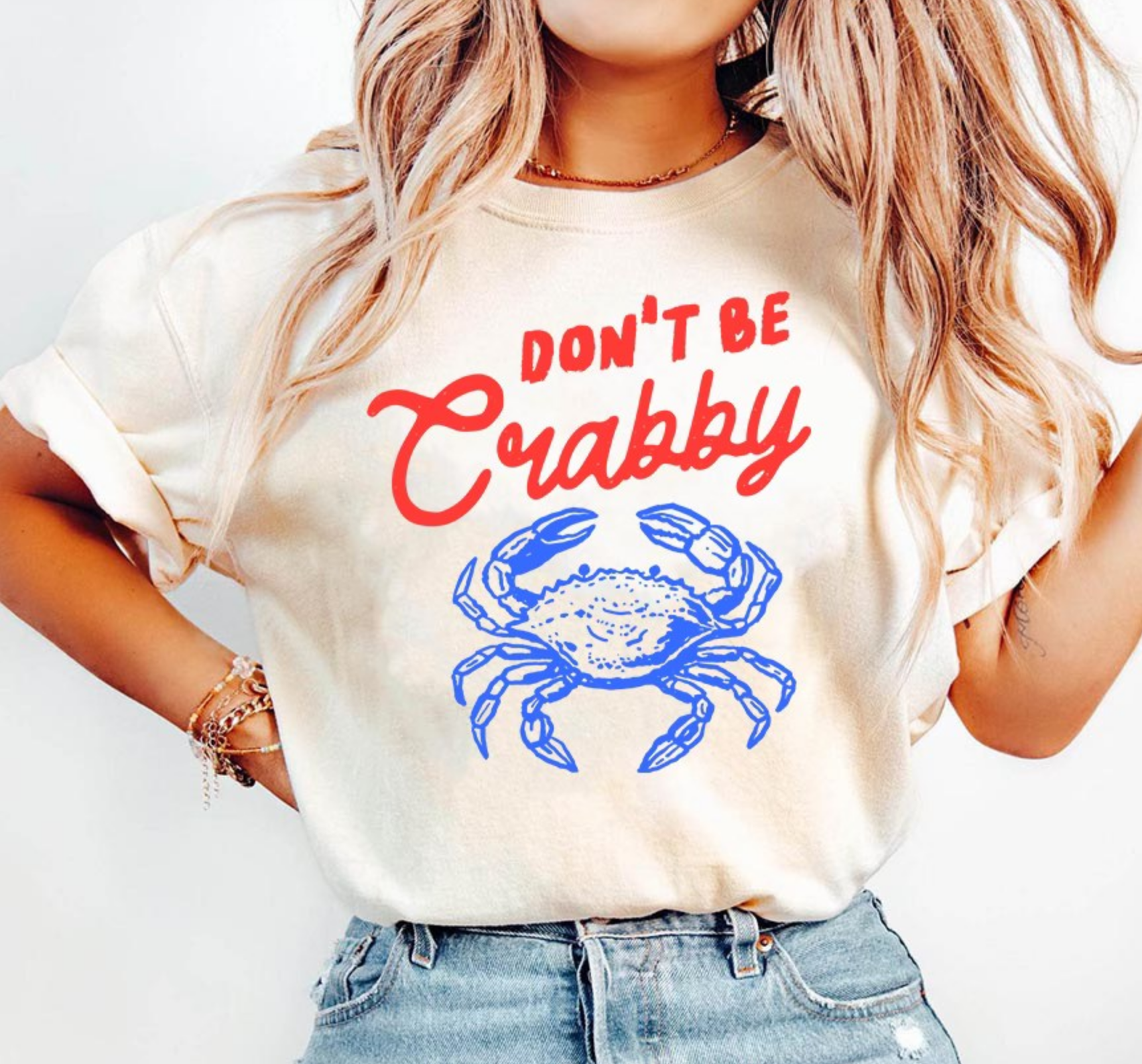 Cream graphic t-shirt featuring Don’t Be Crabby saying with blue crab design for cute coastal summer boutique fashion