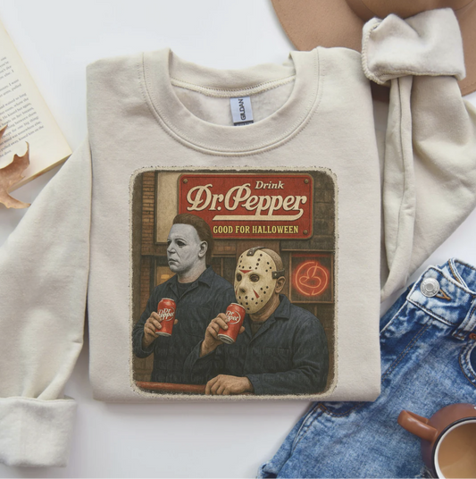 Beige sweatshirt with vintage horror design showing Michael Myers and Jason Voorhees drinking Dr. Pepper with “Good for Halloween” sign