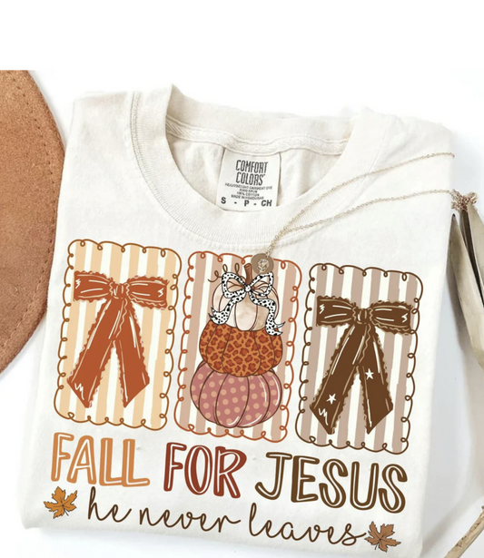 Cream Comfort Colors t-shirt with “Fall for Jesus He Never Leaves” design featuring pumpkins, bows, and autumn colors