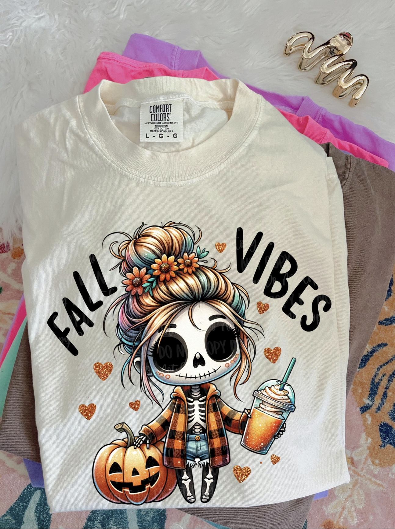 White tee with “Fall Vibes” text, skeleton girl holding coffee, pumpkin beside her.

Close-up of Fall Vibes skeleton design with flowers, plaid, and iced coffee.