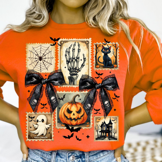 Bright orange Halloween sweatshirt with vintage postage stamp-style graphics including pumpkin, ghost, black cat, haunted house, spiderweb, and skeleton hand, with black ribbon bow details.