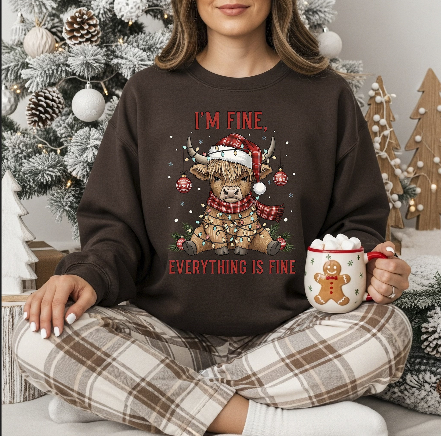 Woman wearing dark brown sweatshirt with funny Highland cow wrapped in lights and ornaments.

Close-up of Christmas cow graphic with “I’m Fine Everything Is Fine” text.

Festive holiday crewneck styled in cozy indoor setting.

Christmas humor sweatshirt featuring cute decorated cow.