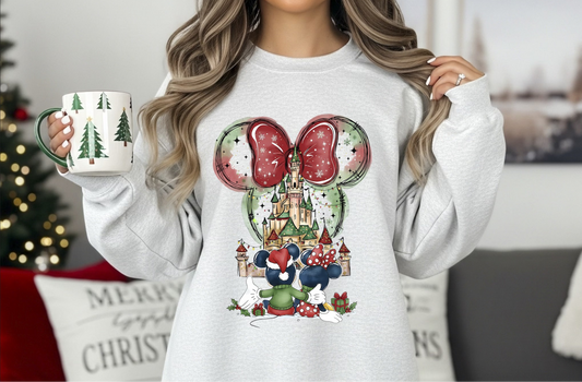 Woman wearing light gray sweatshirt with festive holiday castle and bow design.

Close-up of holiday castle graphic with winter bow and seasonal elements.

Cozy Christmas castle-themed crewneck styled for winter.

Festive holiday sweatshirt with magical castle artwork.