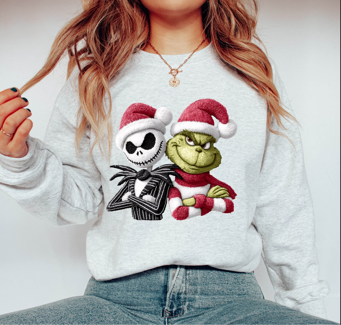 Grey sweatshirt with two festive cartoon characters wearing Santa hats, drawn in a quirky holiday style.
