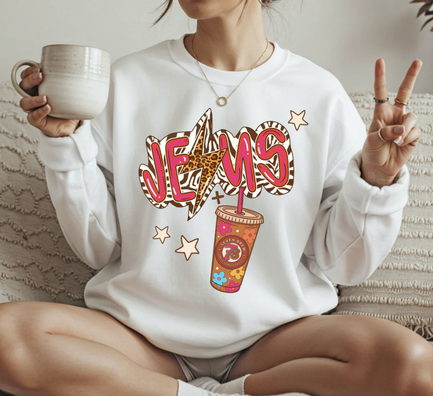 White sweatshirt with colorful “Jesus” text and coffee cup graphic in trendy boutique style