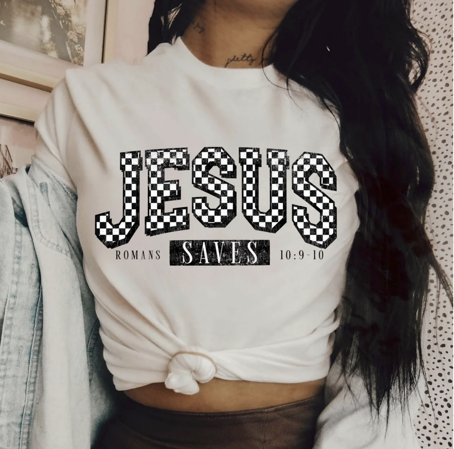 "Jesus Saves t-shirt with Romans 10:9-10 scripture graphic"

"Christian faith tee with checkerboard Jesus lettering"

"Bold black and white Christian graphic t-shirt unisex"