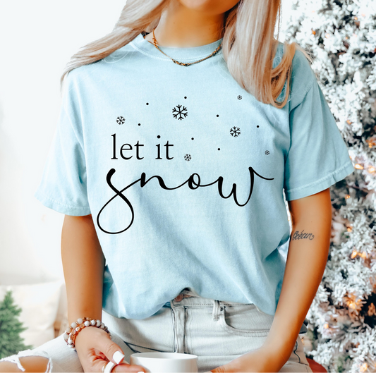 Light blue t-shirt with black script “let it snow” and scattered snowflakes.