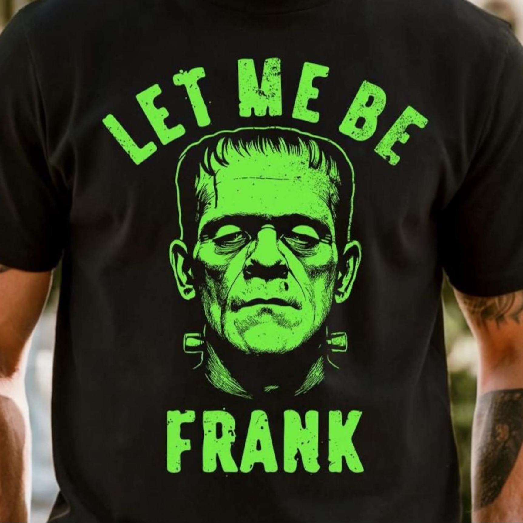Black T-shirt with neon green Frankenstein graphic and text “Let Me Be Frank”