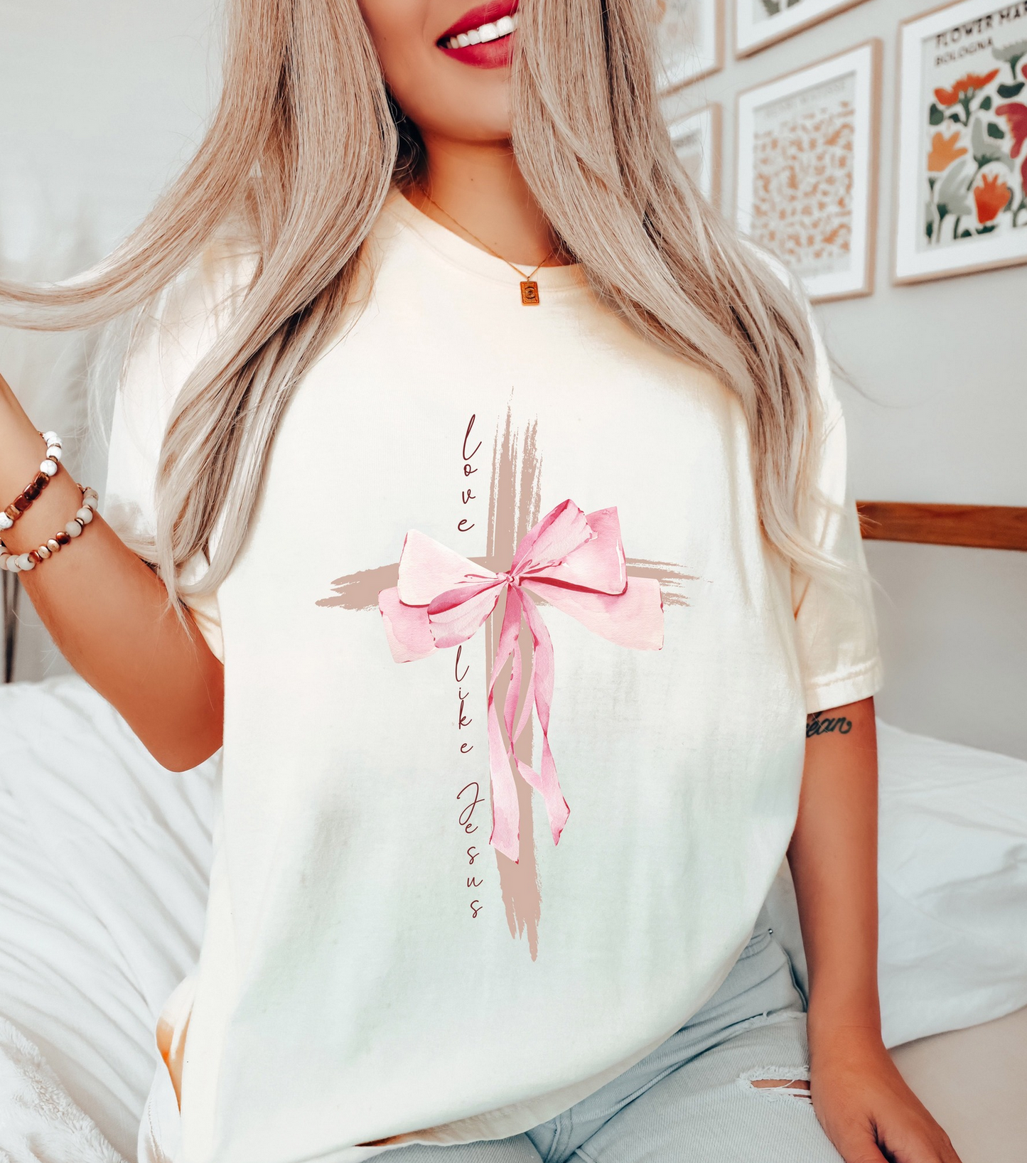 Cream graphic t-shirt featuring a cross design with pink bow and faith-inspired lettering