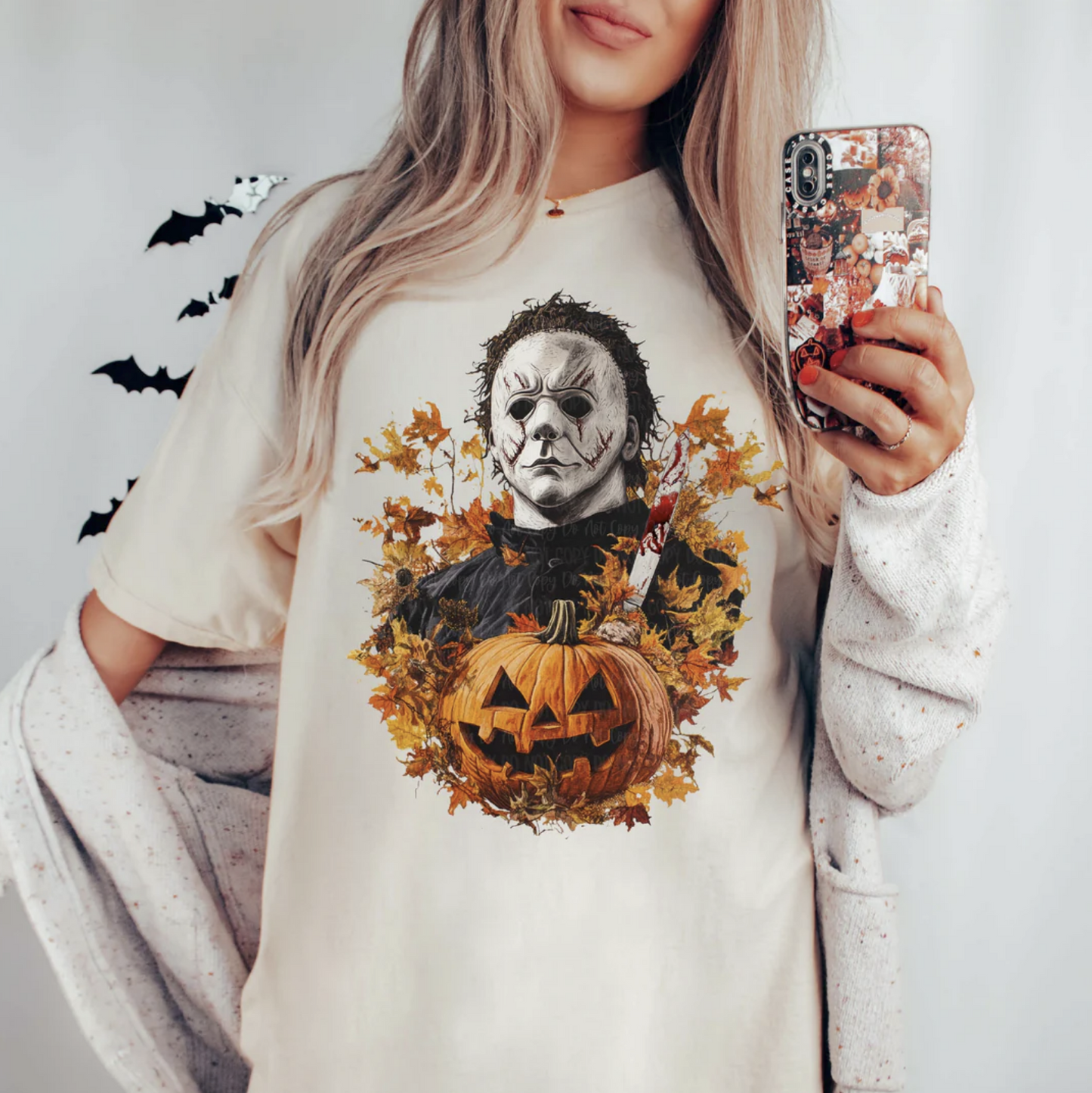 "Michael Myers Halloween t-shirt with pumpkin and fall leaves"

"Spooky season graphic tee featuring Michael Myers and pumpkin"

"Horror slasher movie inspired Michael Myers shirt"