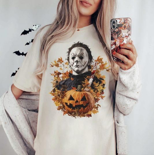 "Michael Myers Halloween t-shirt with pumpkin and fall leaves"

"Spooky season graphic tee featuring Michael Myers and pumpkin"

"Horror slasher movie inspired Michael Myers shirt"