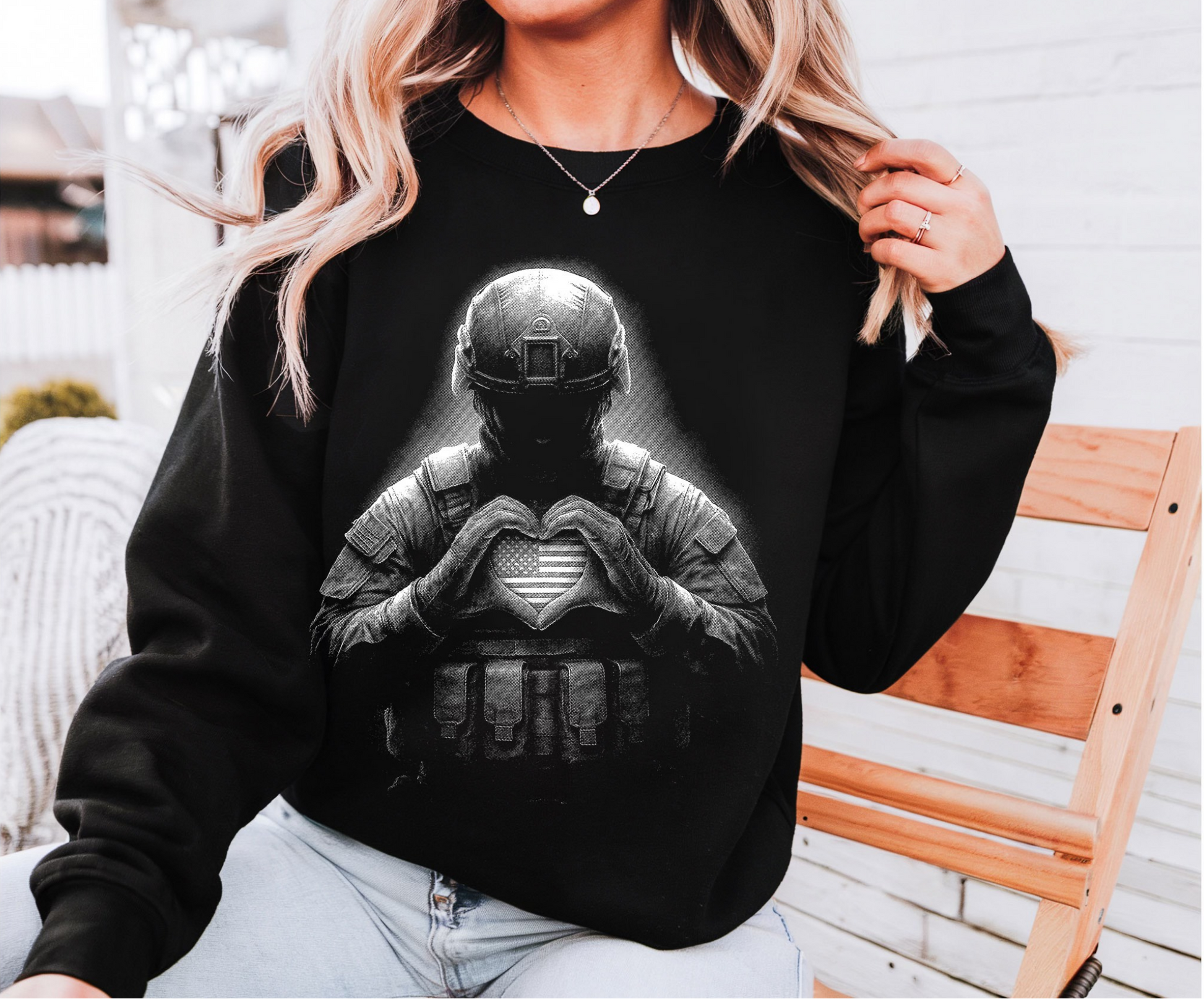 Black graphic sweatshirt featuring armored soldier forming a heart symbol with hands