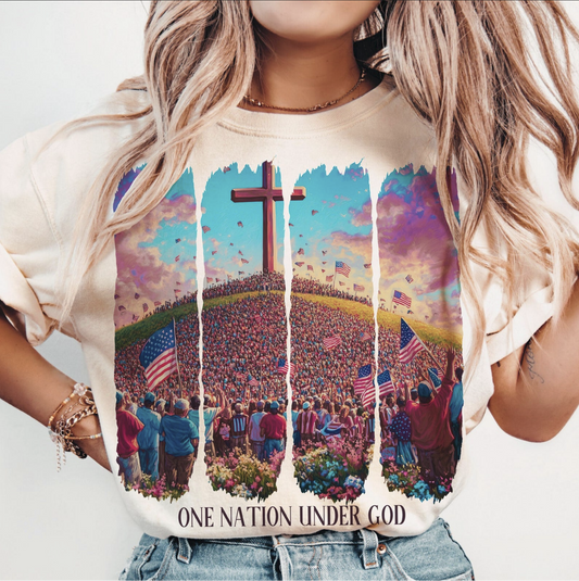 One Nation Under God graphic tee with cross, American flags, and patriotic Christian crowd design on beige shirt
