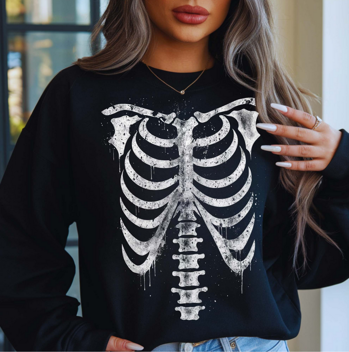 Black Skeleton Ribcage sweatshirt with white bone graphic print, worn by a woman indoors with long wavy hair.