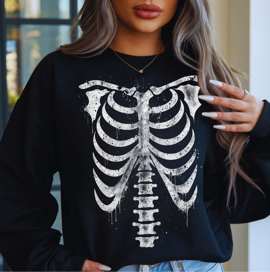 Black Skeleton Ribcage sweatshirt with white bone graphic print, worn by a woman indoors with long wavy hair.
