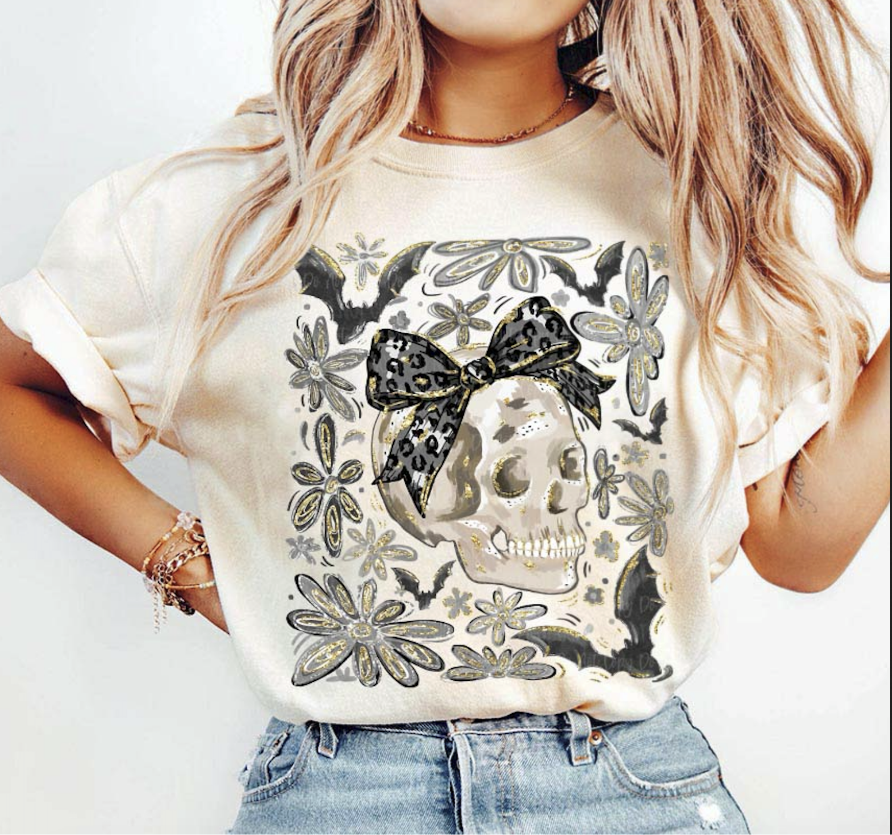 "Beige t-shirt with skull graphic, leopard bow, bats, and floral accents – gothic Halloween tee"