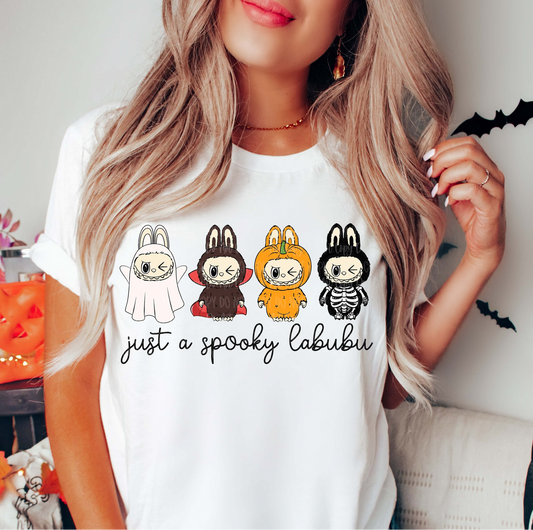 "White Halloween t-shirt with four Labubu-inspired characters in costumes – Just a Spooky Labubu"

"Cute spooky Labubu-inspired graphic tee for Halloween season"