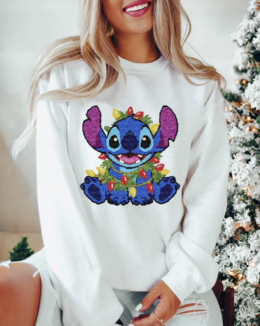 Cute blue wearing Christmas lights on a white holiday sweatshirt.