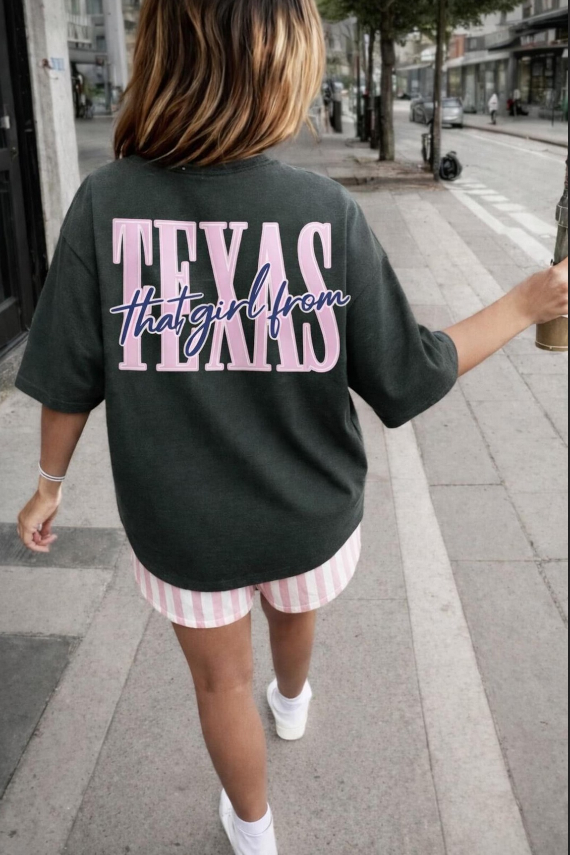 Dark oversized graphic t-shirt featuring That Girl From Texas pink and blue lettering on the back for cute southern boutique fashion