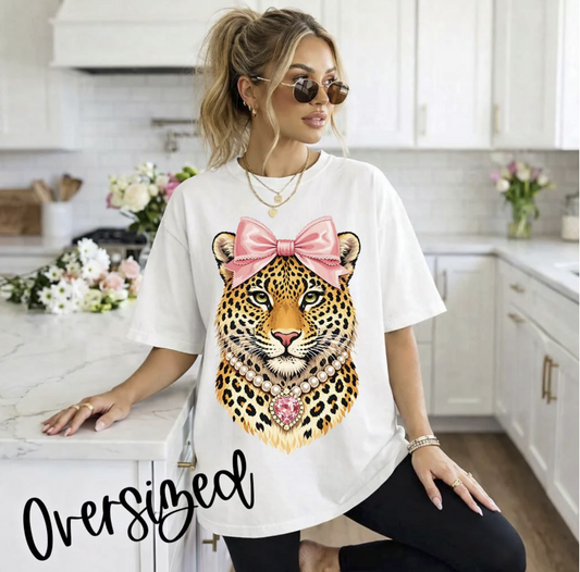 White oversized t-shirt featuring a leopard face with a pink bow and pearl necklace graphic