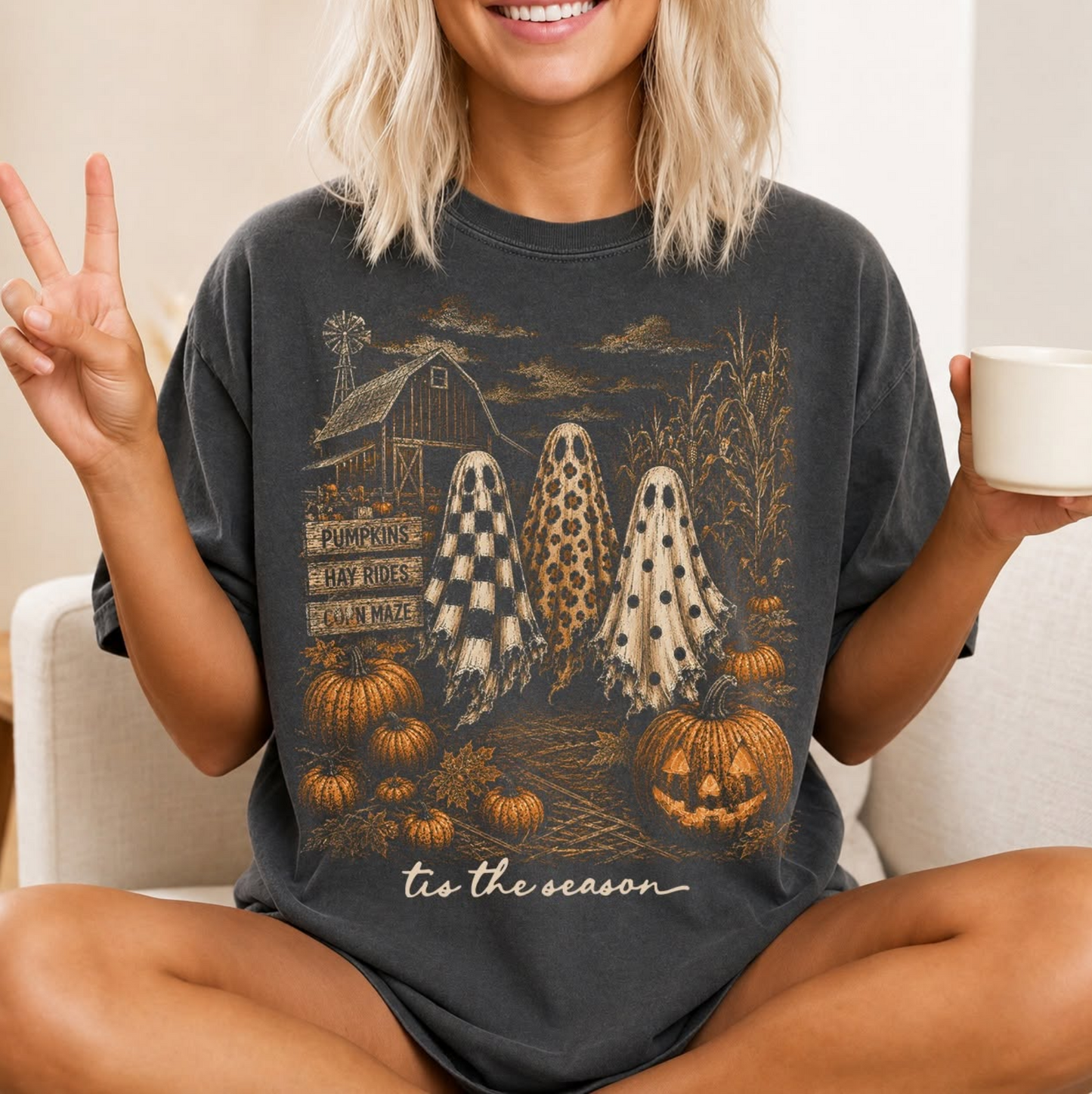 Vintage-style black graphic t-shirt featuring three patterned ghosts at a pumpkin patch with pumpkins, barn, corn stalks, and the phrase "'Tis the Season."