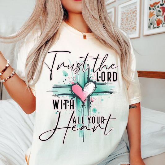 Trust the Lord With All Your Heart Christian graphic tee with watercolor cross and pink heart design on beige shirt
