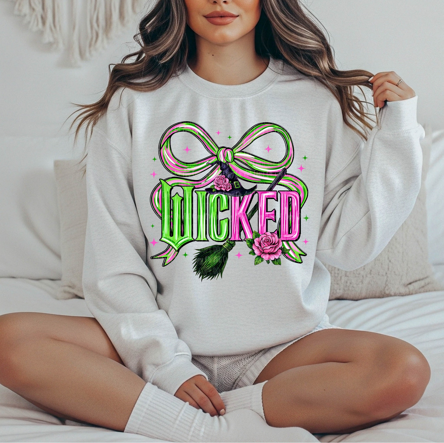 Woman wearing a white sweatshirt with pink and green “Wicked” graphic and bow illustration.

Retro witchy aesthetic crewneck with bright bow and floral accents.

Cozy magical vibe sweatshirt styled for everyday wear.

White unisex sweatshirt with bold Wicked lettering and cute pastel details.