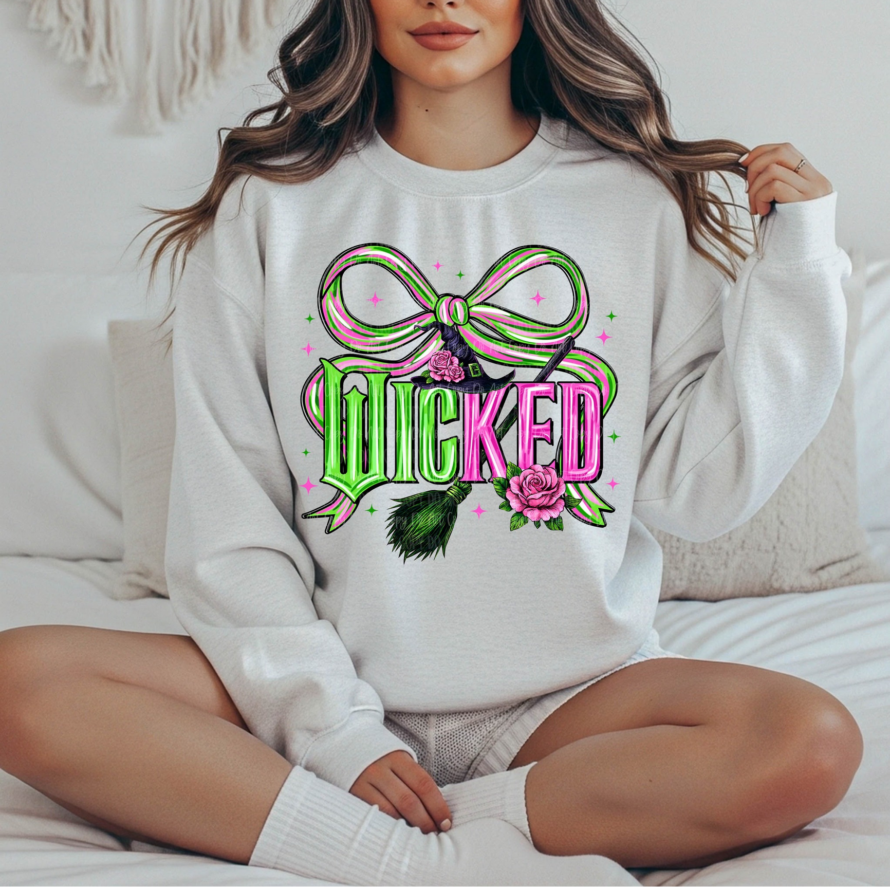 Woman wearing a white sweatshirt with pink and green “Wicked” graphic and bow illustration.

Retro witchy aesthetic crewneck with bright bow and floral accents.

Cozy magical vibe sweatshirt styled for everyday wear.

White unisex sweatshirt with bold Wicked lettering and cute pastel details.