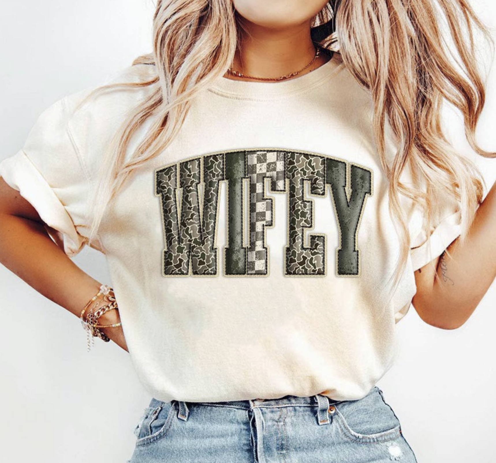Beige graphic tee with bold camo patchwork letters spelling WIFEY