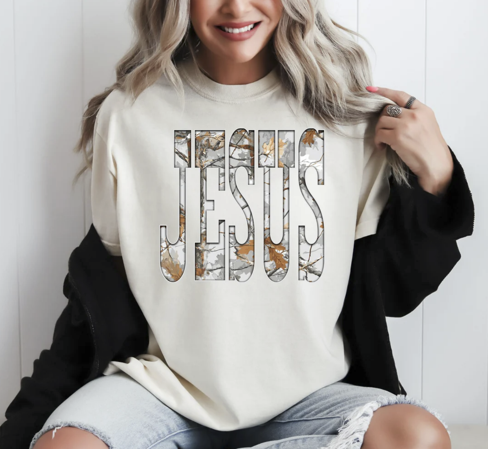 Woman wearing beige JESUS camo print t-shirt holding coffee mug

Faith-based neutral tee with bold JESUS lettering in camo pattern

Christian unisex t-shirt styled with casual outfit

Inspirational graphic tee for faith and everyday wear